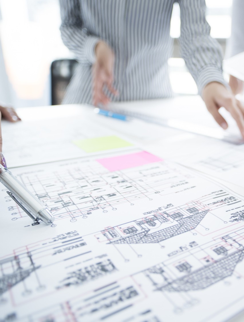 They are meeting at the office looking at the design drawing